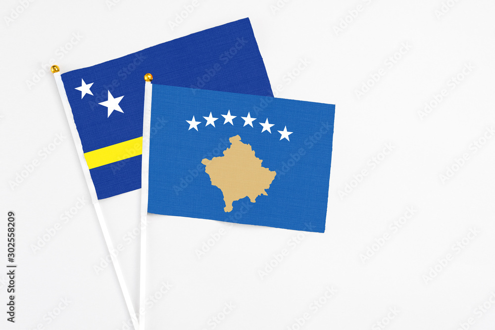 Kosovo and Curacao stick flags on white background. High quality fabric, miniature national flag. Peaceful global concept.White floor for copy space. Kosovo and Curacao stick flags on white background. High quality fabric, miniature national flag. Peaceful global concept.White floor for copy space.