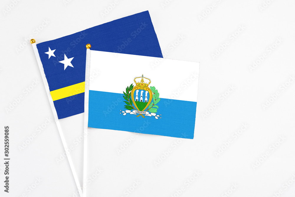 San Marino and Curacao stick flags on white background. High quality fabric, miniature national flag. Peaceful global concept.White floor for copy space. San Marino and Curacao stick flags on white background. High quality fabric, miniature national flag. Peaceful global concept.White floor for copy space.