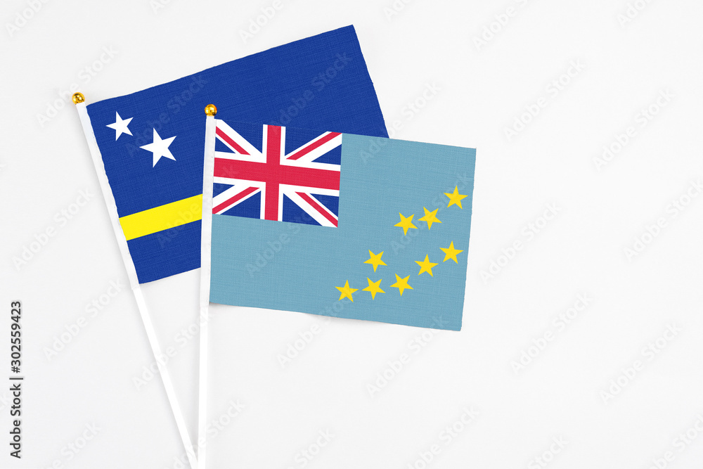 Tuvalu and Curacao stick flags on white background. High quality fabric, miniature national flag. Peaceful global concept.White floor for copy space. Tuvalu and Curacao stick flags on white background. High quality fabric, miniature national flag. Peaceful global concept.White floor for copy space.