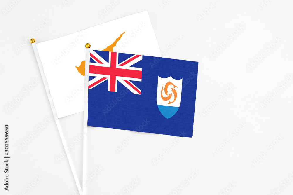 Fototapeta premium Anguilla and Cyprus stick flags on white background. High quality fabric, miniature national flag. Peaceful global concept.White floor for copy space.