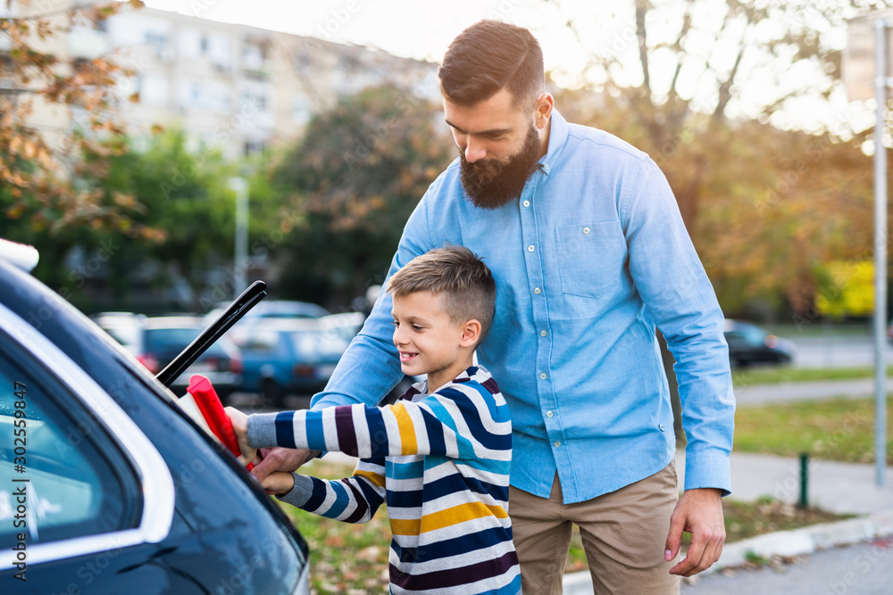 Father and son washing their car together.