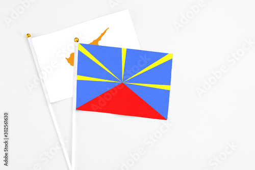 Reunion and Cyprus stick flags on white background. High quality fabric, miniature national flag. Peaceful global concept.White floor for copy space.