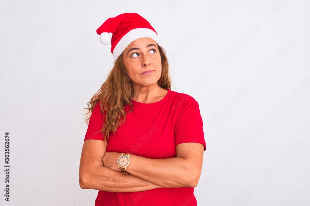 Middle age mature woman wearing christmas hat over isolated background smiling looking to the side and staring away thinking. Middle age mature woman wearing christmas hat over isolated background smiling looking to the side and staring away thinking.