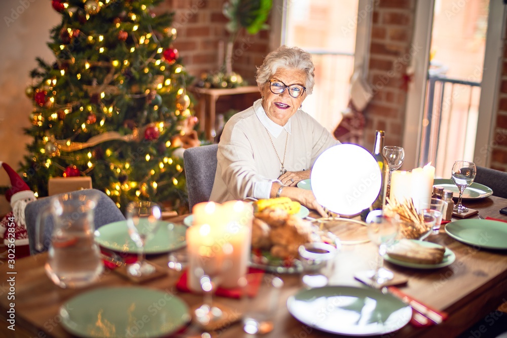 Adorable senior woman smiling happy and confident. Sitting prepared to celebrate christmas at home Adorable senior woman smiling happy and confident. Sitting prepared to celebrate christmas at home