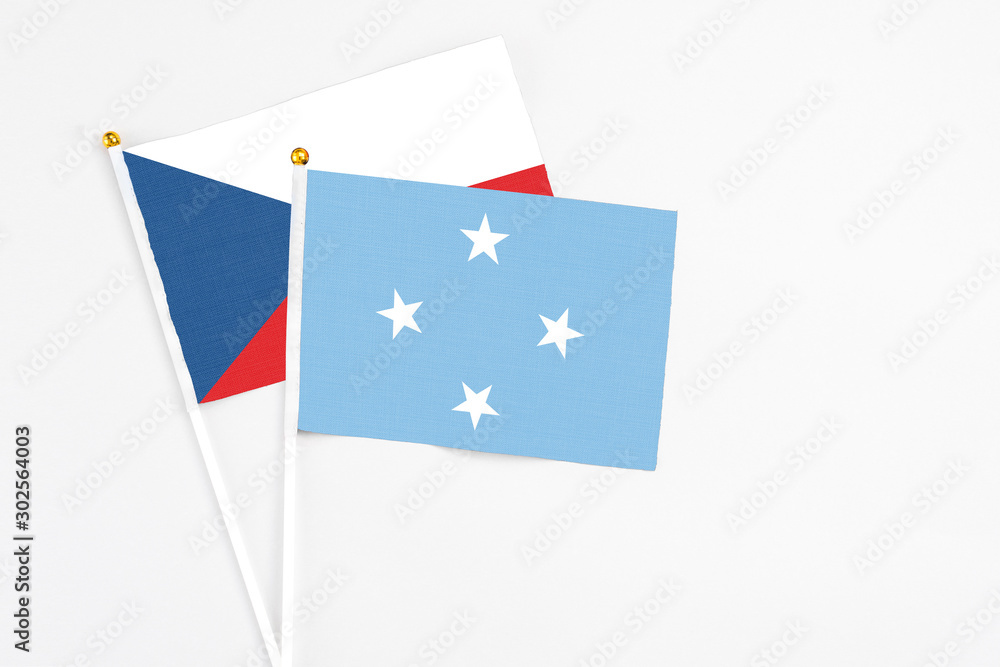 Micronesia and Cyprus stick flags on white background. High quality fabric, miniature national flag. Peaceful global concept.White floor for copy space.