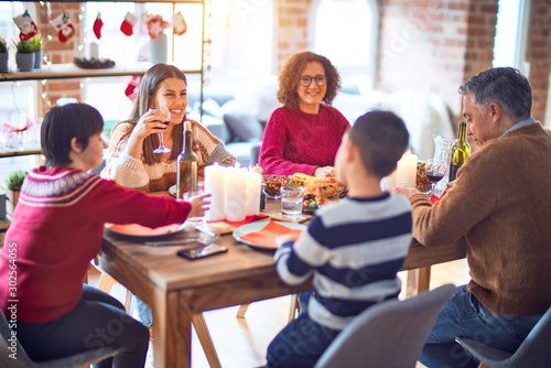 Beautiful family smiling happy and confident. Eating roasted turkey celebrating christmas at home