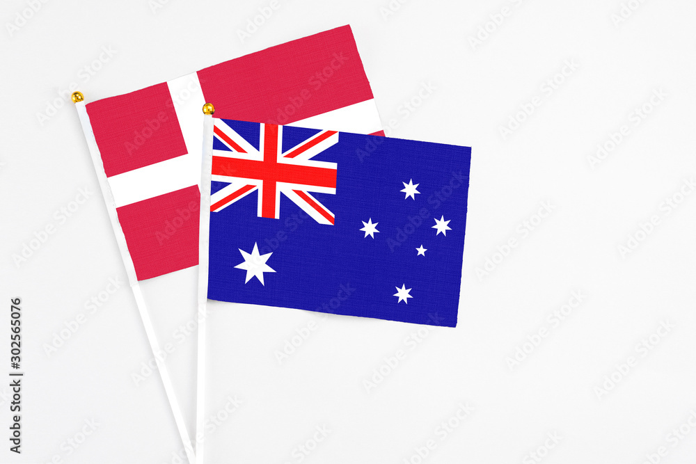 Fototapeta premium Australia and Denmark stick flags on white background. High quality fabric, miniature national flag. Peaceful global concept.White floor for copy space.