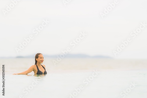 Portrait beautiful young asian woman wear bikini around swimming pool in hotel resort nearly sea ocean beach © siraphol