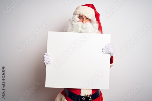 Middle age man wearing Santa Claus costume holding banner over isolated white background with a happy face standing and smiling with a confident smile showing teeth
