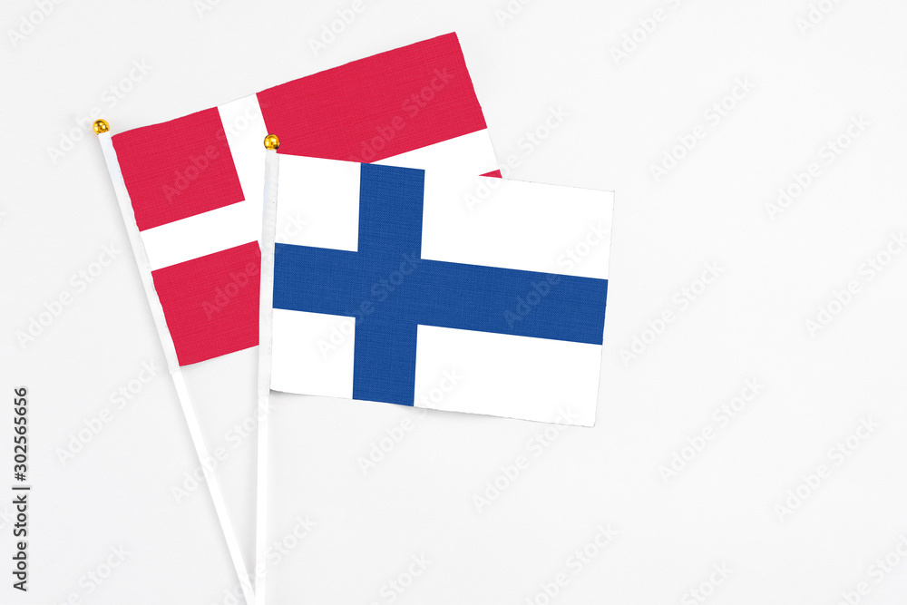 Finland and Denmark stick flags on white background. High quality fabric, miniature national flag. Peaceful global concept.White floor for copy space.