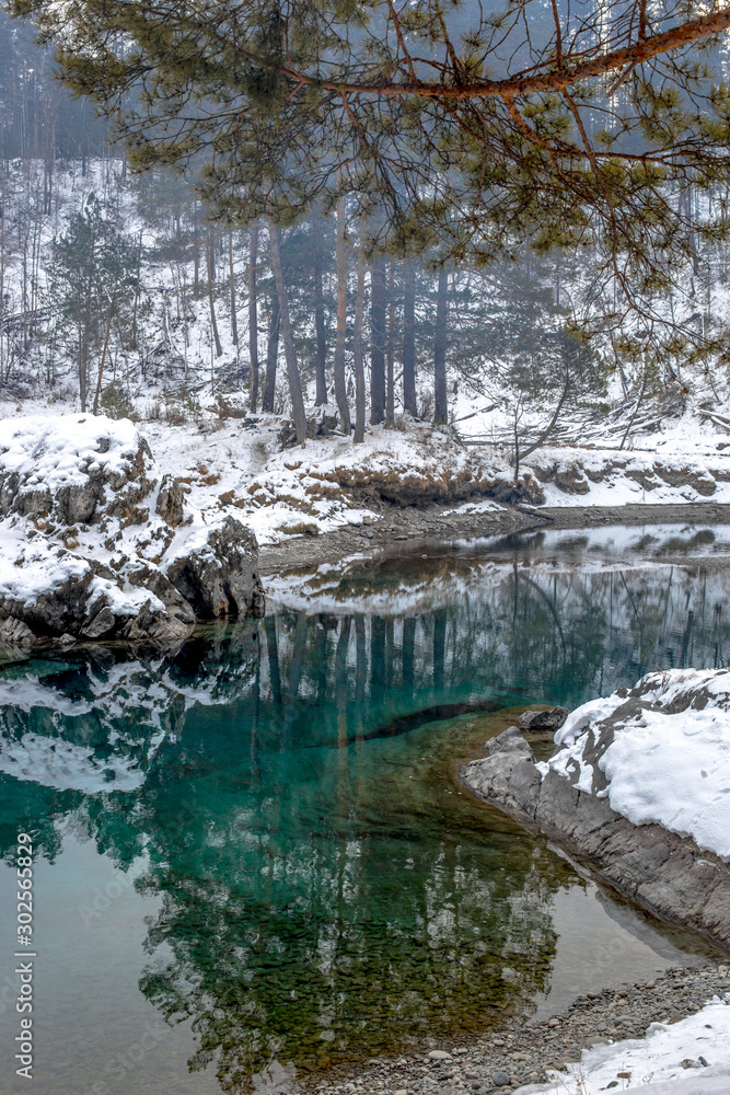Beautiful blue ice-free lake of Siberia in winter. Katun river in winter. Russia, Altai Region, Siberia. Beautiful blue ice-free lake of Siberia in winter. Katun river in winter. Russia, Altai Region, Siberia.