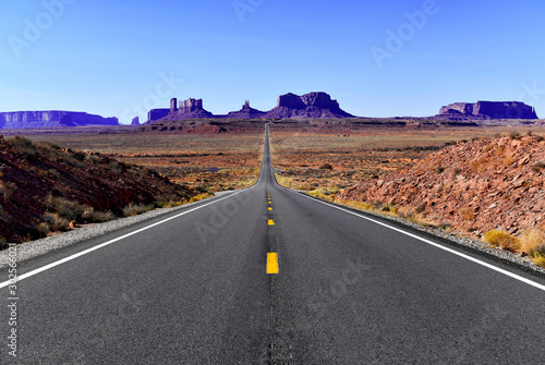Road into the red rock desert landscape of Monument Valley, Navajo Tribal Park in the southwest USA in Arizona and Utah