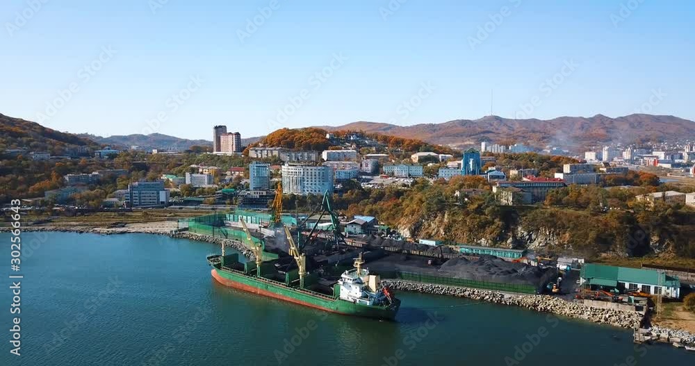 Coal port. Flying over a coal port in the small town of Nakhodka. Coal loading on a cargo ship in the sea coal port. Coal port. Flying over a coal port in the small town of Nakhodka. Coal loading on a cargo ship in the sea coal port.