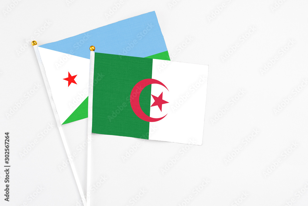 Algeria and Djibouti stick flags on white background. High quality fabric, miniature national flag. Peaceful global concept.White floor for copy space. Algeria and Djibouti stick flags on white background. High quality fabric, miniature national flag. Peaceful global concept.White floor for copy space.