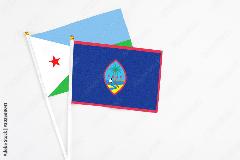 Guam and Djibouti stick flags on white background. High quality fabric, miniature national flag. Peaceful global concept.White floor for copy space. Guam and Djibouti stick flags on white background. High quality fabric, miniature national flag. Peaceful global concept.White floor for copy space.