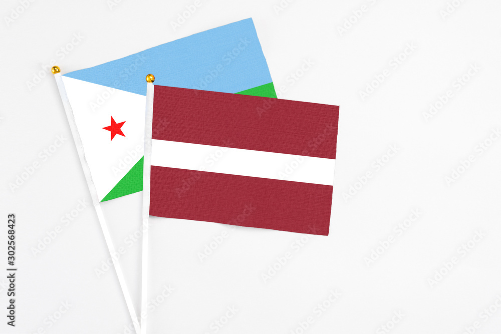 Latvia and Djibouti stick flags on white background. High quality fabric, miniature national flag. Peaceful global concept.White floor for copy space. Latvia and Djibouti stick flags on white background. High quality fabric, miniature national flag. Peaceful global concept.White floor for copy space.