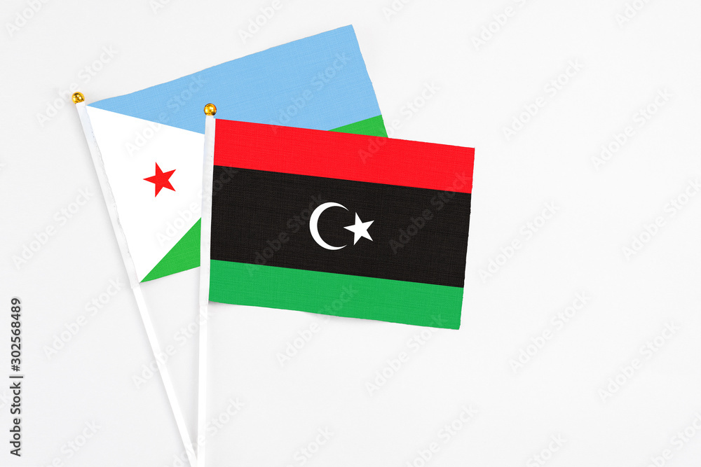 Libya and Djibouti stick flags on white background. High quality fabric, miniature national flag. Peaceful global concept.White floor for copy space. Libya and Djibouti stick flags on white background. High quality fabric, miniature national flag. Peaceful global concept.White floor for copy space.