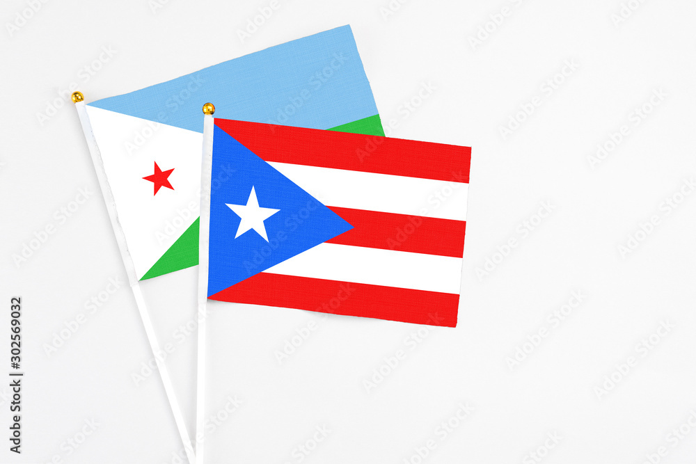 Puerto Rico and Djibouti stick flags on white background. High quality fabric, miniature national flag. Peaceful global concept.White floor for copy space. Puerto Rico and Djibouti stick flags on white background. High quality fabric, miniature national flag. Peaceful global concept.White floor for copy space.