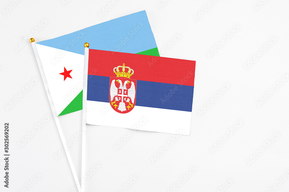 Serbia and Djibouti stick flags on white background. High quality fabric, miniature national flag. Peaceful global concept.White floor for copy space. Serbia and Djibouti stick flags on white background. High quality fabric, miniature national flag. Peaceful global concept.White floor for copy space.