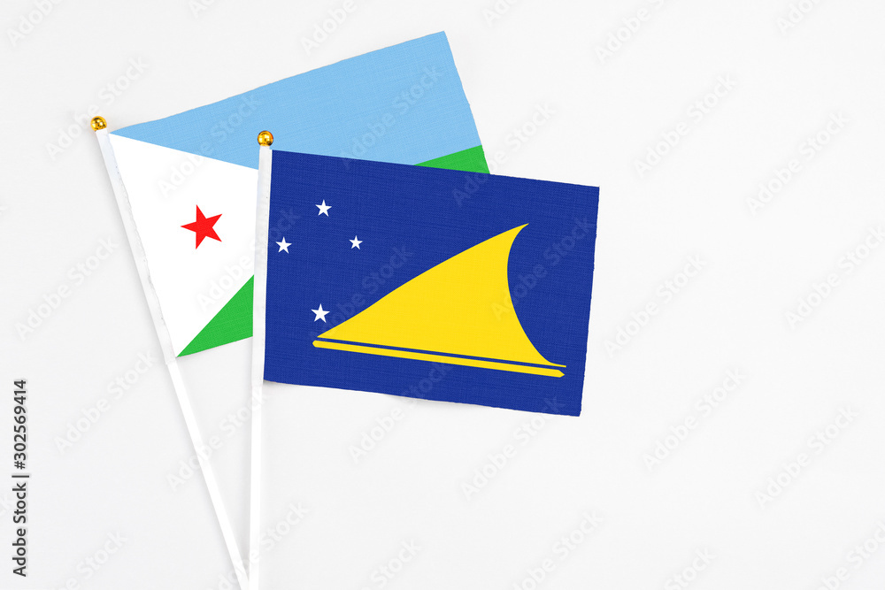 Tokelau and Djibouti stick flags on white background. High quality fabric, miniature national flag. Peaceful global concept.White floor for copy space. Tokelau and Djibouti stick flags on white background. High quality fabric, miniature national flag. Peaceful global concept.White floor for copy space.
