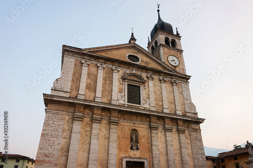 Cityscape with Church Santa Maria Assunta on rock at Sarca Valley near Garda lake of Trentino in Italy. Street with Cathedral on mountain at Arco town in Trento near Riva del Garda photo