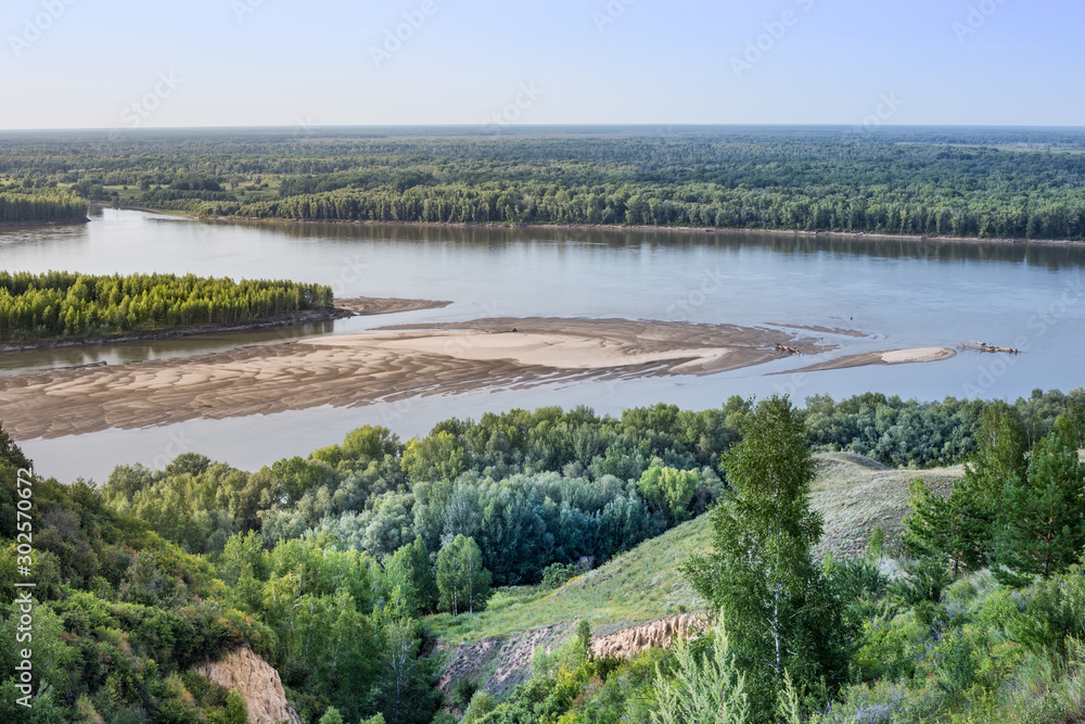 The Ob river, Altai Krai, Siberia, Russia. Summer river landscape, view of the river from a height. Shoals on the Ob river in August.