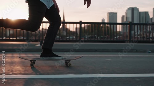 skateboarder pushing on bridge in super slow motion in front frankfurt skyline skyscrapers sunset