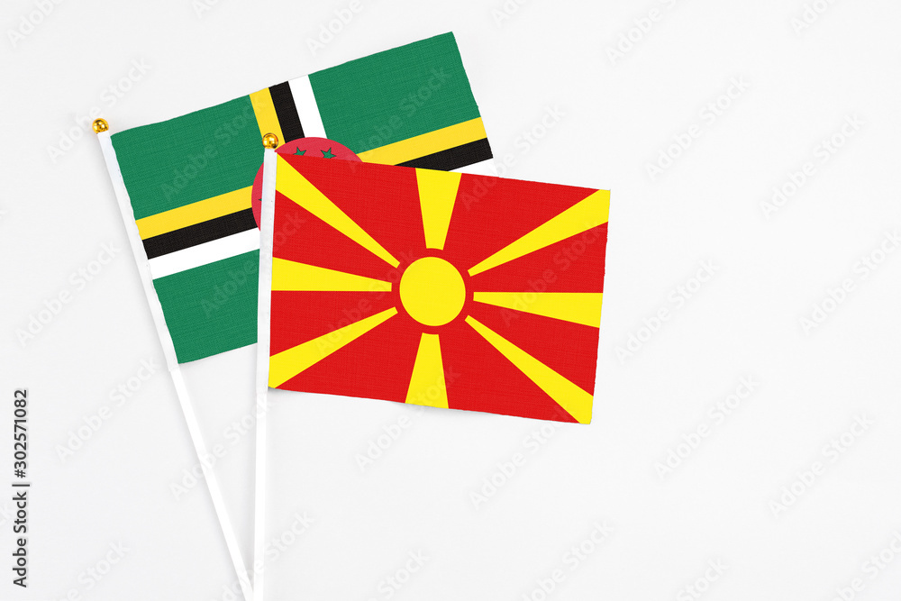 Macedonia and Dominica stick flags on white background. High quality fabric, miniature national flag. Peaceful global concept.White floor for copy space.