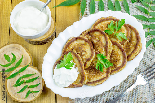Pancakes of rye flour with sour cream on a wooden table. Tasty and healthy Breakfast.