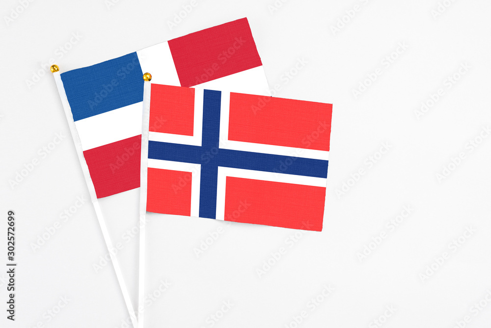 Bouvet Islands and Dominican Republic stick flags on white background. High quality fabric, miniature national flag. Peaceful global concept.White floor for copy space.