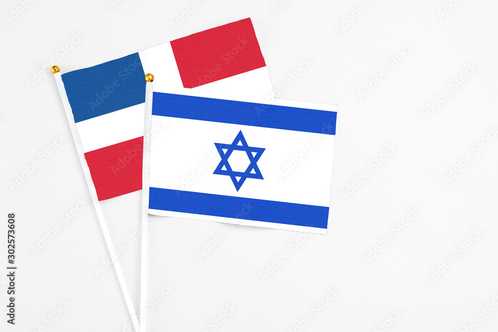 Israel and Dominican Republic stick flags on white background. High quality fabric, miniature national flag. Peaceful global concept.White floor for copy space.