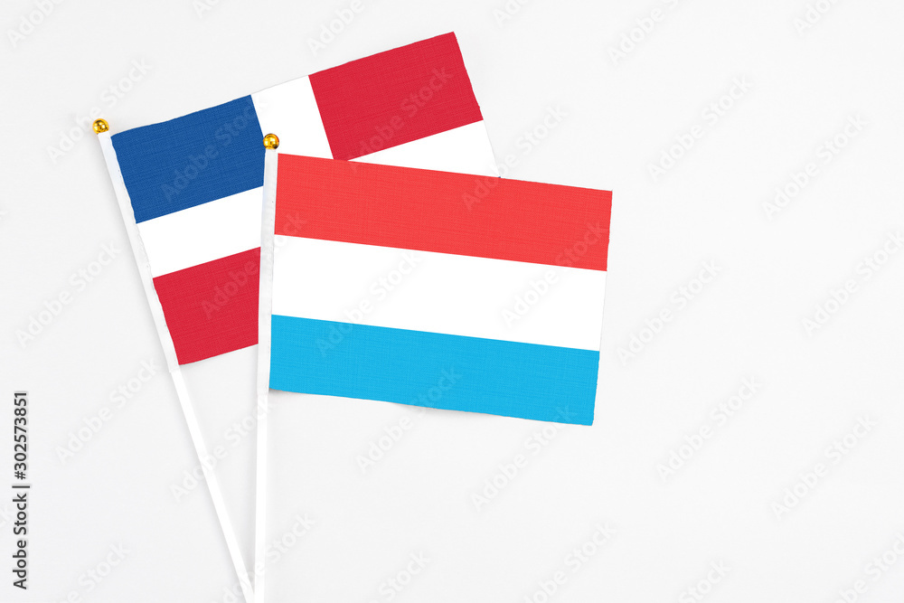 Luxembourg and Dominican Republic stick flags on white background. High quality fabric, miniature national flag. Peaceful global concept.White floor for copy space. Luxembourg and Dominican Republic stick flags on white background. High quality fabric, miniature national flag. Peaceful global concept.White floor for copy space.