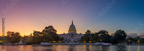 Panoramiczny obraz Kapitolu Stanów Zjednoczonych z kapitolu odbijającego basen w świetle poranka.