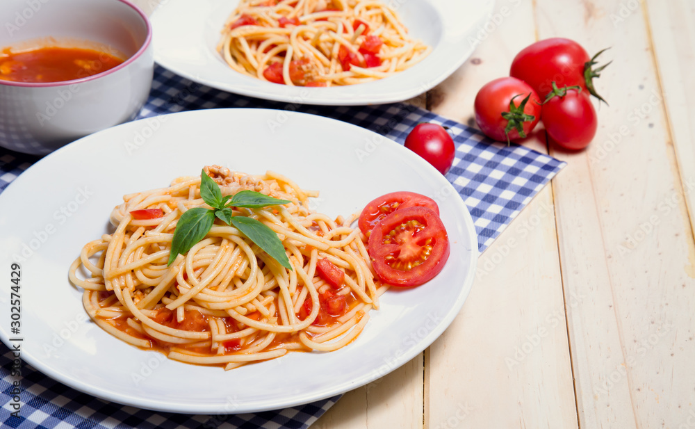 Spaghetti pasta with and tomato sauce on wood background