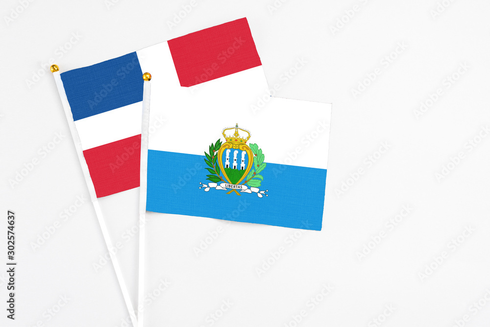 San Marino and Dominican Republic stick flags on white background. High quality fabric, miniature national flag. Peaceful global concept.White floor for copy space. San Marino and Dominican Republic stick flags on white background. High quality fabric, miniature national flag. Peaceful global concept.White floor for copy space.