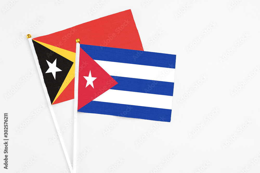Cuba and East Timor stick flags on white background. High quality fabric, miniature national flag. Peaceful global concept.White floor for copy space.