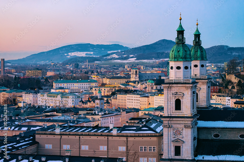 Panorama of Salzburg and Cathedral with snow from Hohensalzburg castle in Austria in evening. Landscape and cityscape of Mozart city in Europe at winter. View of old Austrian town of Salzburgerland
