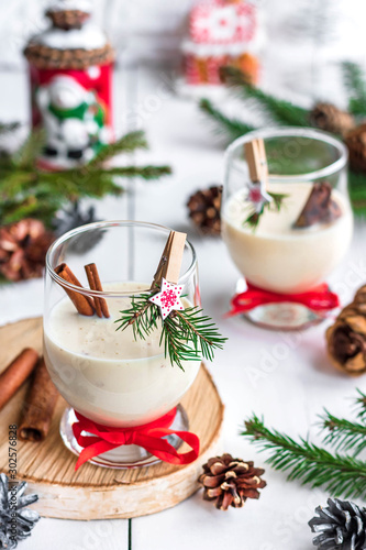Traditional eggnog Christmas cocktail in a glass goblet decorated with New Year clothespin. Non-alcoholic option.