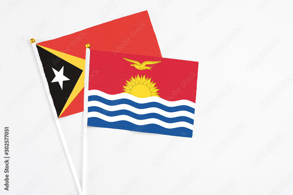 Kiribati and East Timor stick flags on white background. High quality fabric, miniature national flag. Peaceful global concept.White floor for copy space. Kiribati and East Timor stick flags on white background. High quality fabric, miniature national flag. Peaceful global concept.White floor for copy space.