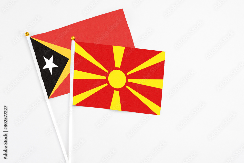 Macedonia and East Timor stick flags on white background. High quality fabric, miniature national flag. Peaceful global concept.White floor for copy space.