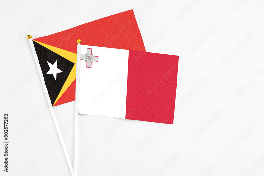 Malta and East Timor stick flags on white background. High quality fabric, miniature national flag. Peaceful global concept.White floor for copy space. Malta and East Timor stick flags on white background. High quality fabric, miniature national flag. Peaceful global concept.White floor for copy space.