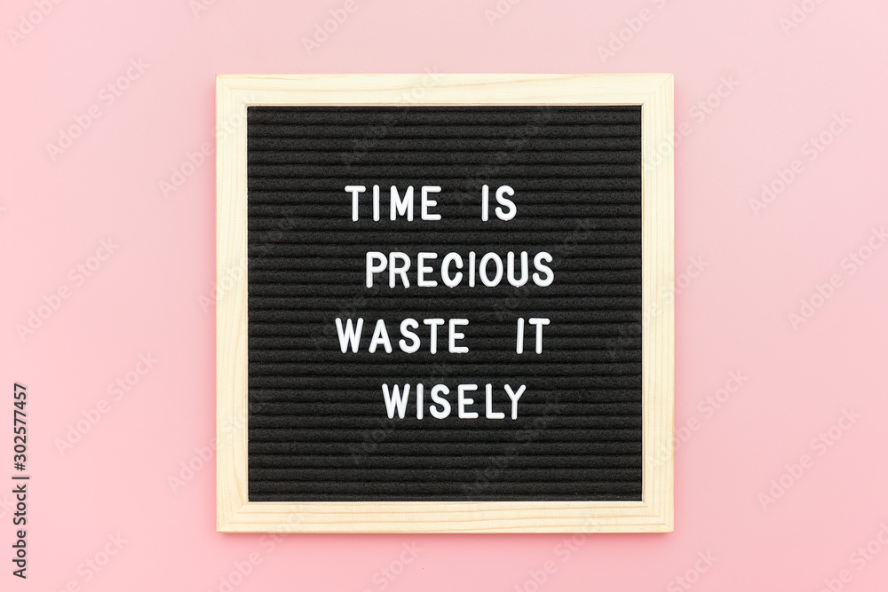 Fototapeta Time is precious waste it wisely. Motivational quote on letterboard on pink background. Top view Flat lay Copy space Concept inspirational quote of the day