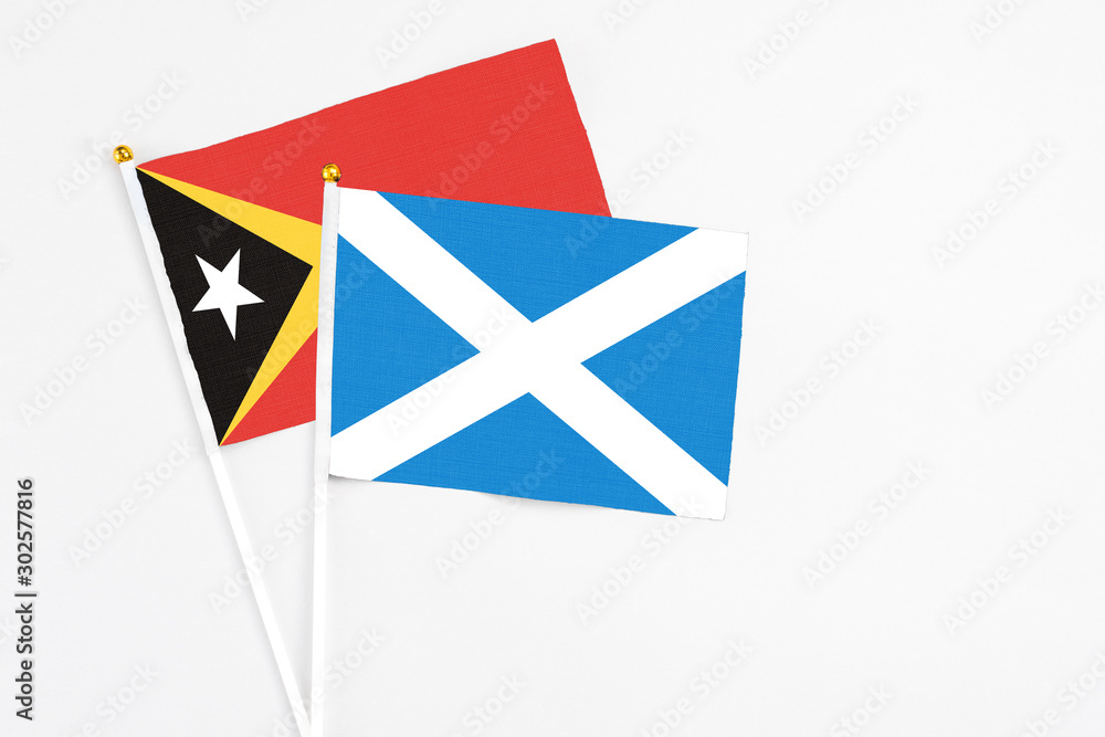 Scotland and East Timor stick flags on white background. High quality fabric, miniature national flag. Peaceful global concept.White floor for copy space. Scotland and East Timor stick flags on white background. High quality fabric, miniature national flag. Peaceful global concept.White floor for copy space.