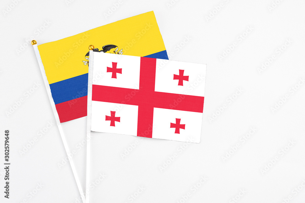 Georgia and Ecuador stick flags on white background. High quality fabric, miniature national flag. Peaceful global concept.White floor for copy space.
