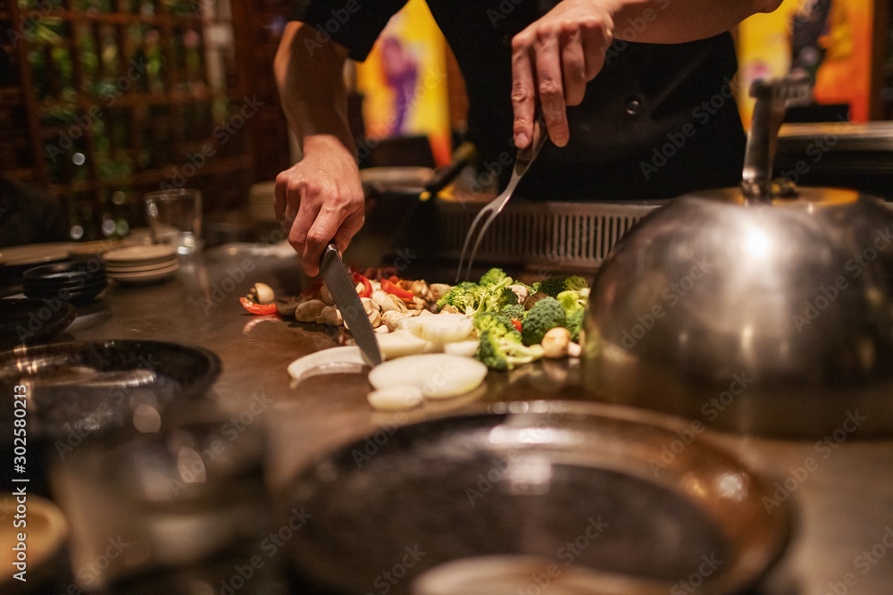 Fotografie Teppanyaki Chef Cooking and Cutting Up Vegetables