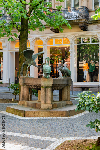 Heron Fountain Reiherbrunnen in Sophienstrasse Street at Old city of Baden Baden at Baden Wurttemberg region, Germany. Cityscape view of square and architecture at Bath and spa German town in Europe. photo