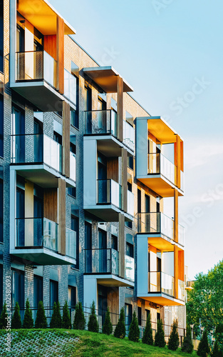 Modern residential apartment with flat building exterior and outdoor facilities. New luxury house and home complex and green yard. City Real estate property and condo architecture. Empty background