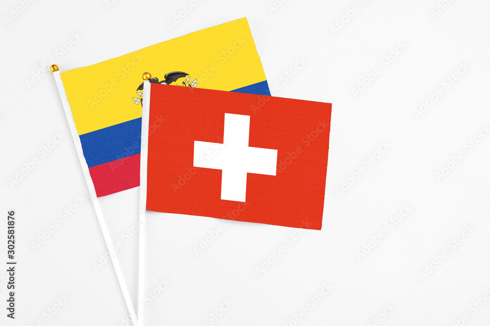 Switzerland and Ecuador stick flags on white background. High quality fabric, miniature national flag. Peaceful global concept.White floor for copy space.