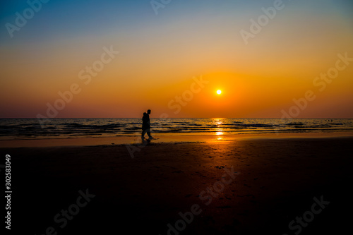 Siluate lovers and beach before sunset