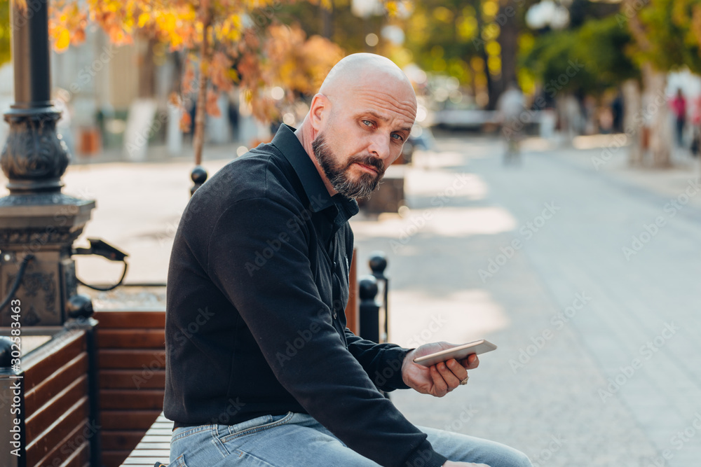 Outdoor portrait of a 50 year old happy man wearing a black shirt and glasses Outdoor portrait of a 50 year old happy man wearing a black shirt and glasses